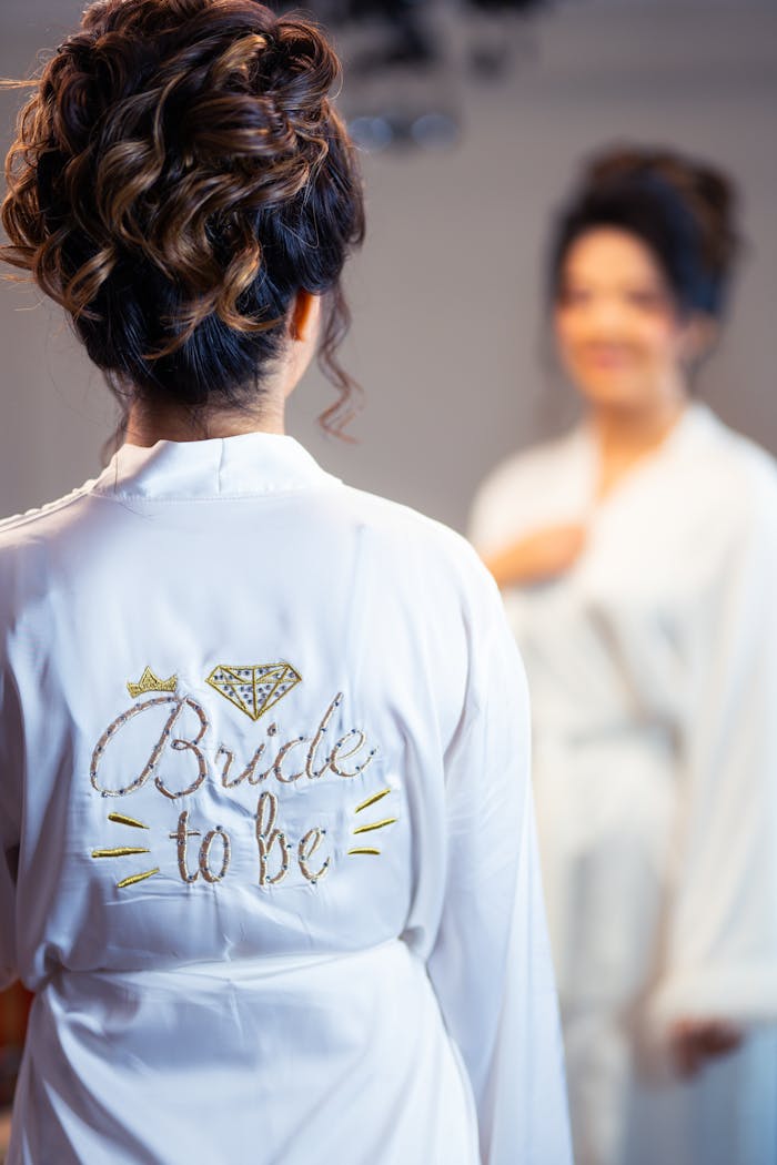 services-02 A woman wearing a 'Bride to Be' robe getting ready in the mirror.